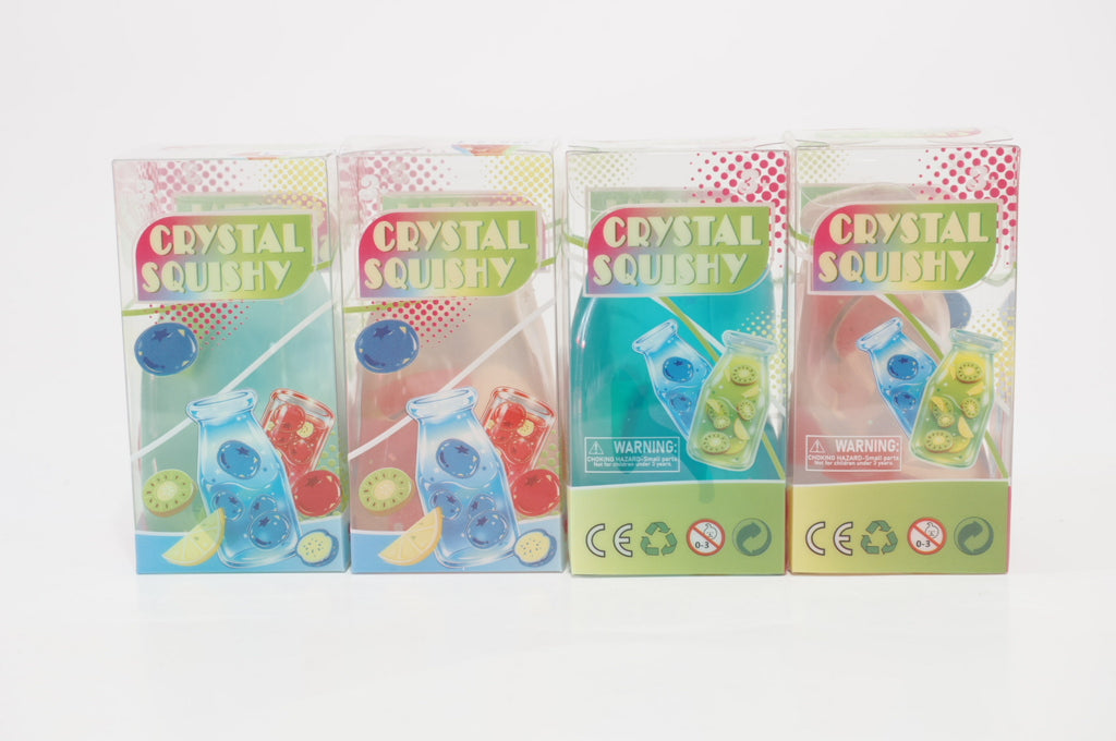 Four colorful Crystal Squishy retail boxes displayed side by side, featuring illustrations of fruit drink bottle-shaped squishy toys and fruit slices.