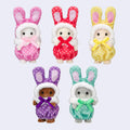 Five Calico Critters baby figures wearing colorful bunny costumes in pink, red, yellow, purple, and mint green, each with long bunny ears and a matching ribbon bow.