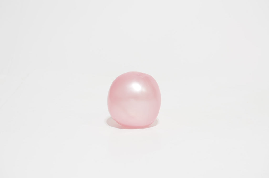 Single translucent pastel pink oil squishy ball with a smooth, rounded shape, displayed against a white background.
