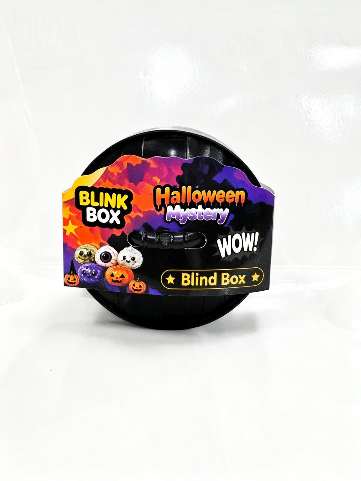 A round black plastic container labeled 'Halloween Mystery Blink Box' with colorful Halloween-themed graphics including pumpkins, ghosts, and spooky clouds, photographed on a white background.