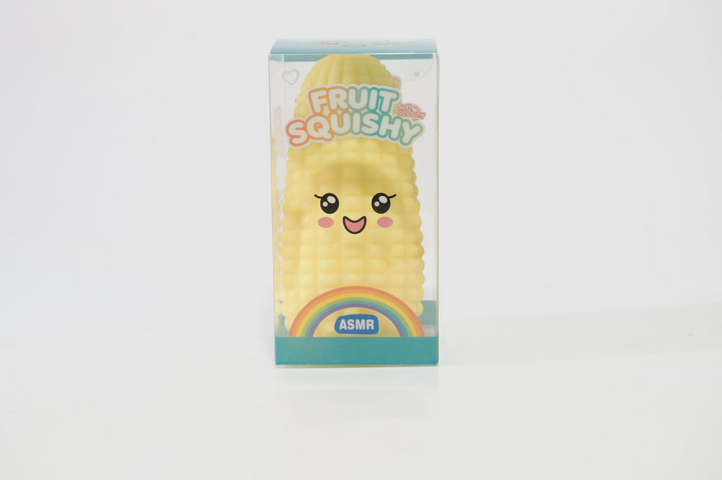Yellow crunchy corn squishy displayed inside its upright retail packaging, decorated with a cartoon corn face and green details near the bottom.