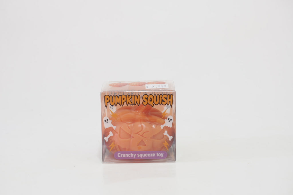 Orange jack-o'-lantern crunchy squishy inside a clear Pumpkin Squish retail box decorated with white ghosts, bones, and Halloween graphics, with a purple Crunchy squeeze toy label.