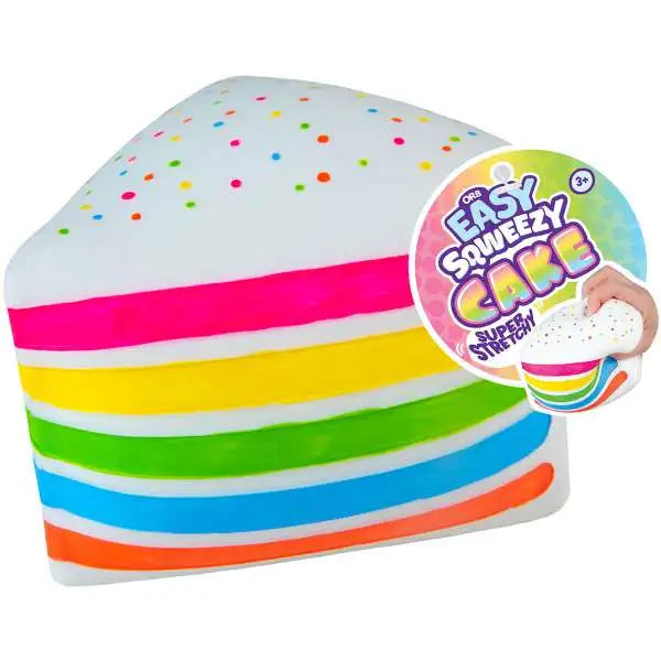 Rainbow cake-slice squishy with white sprinkle-covered frosting and an attached Easy Sqweezy Cake product tag.